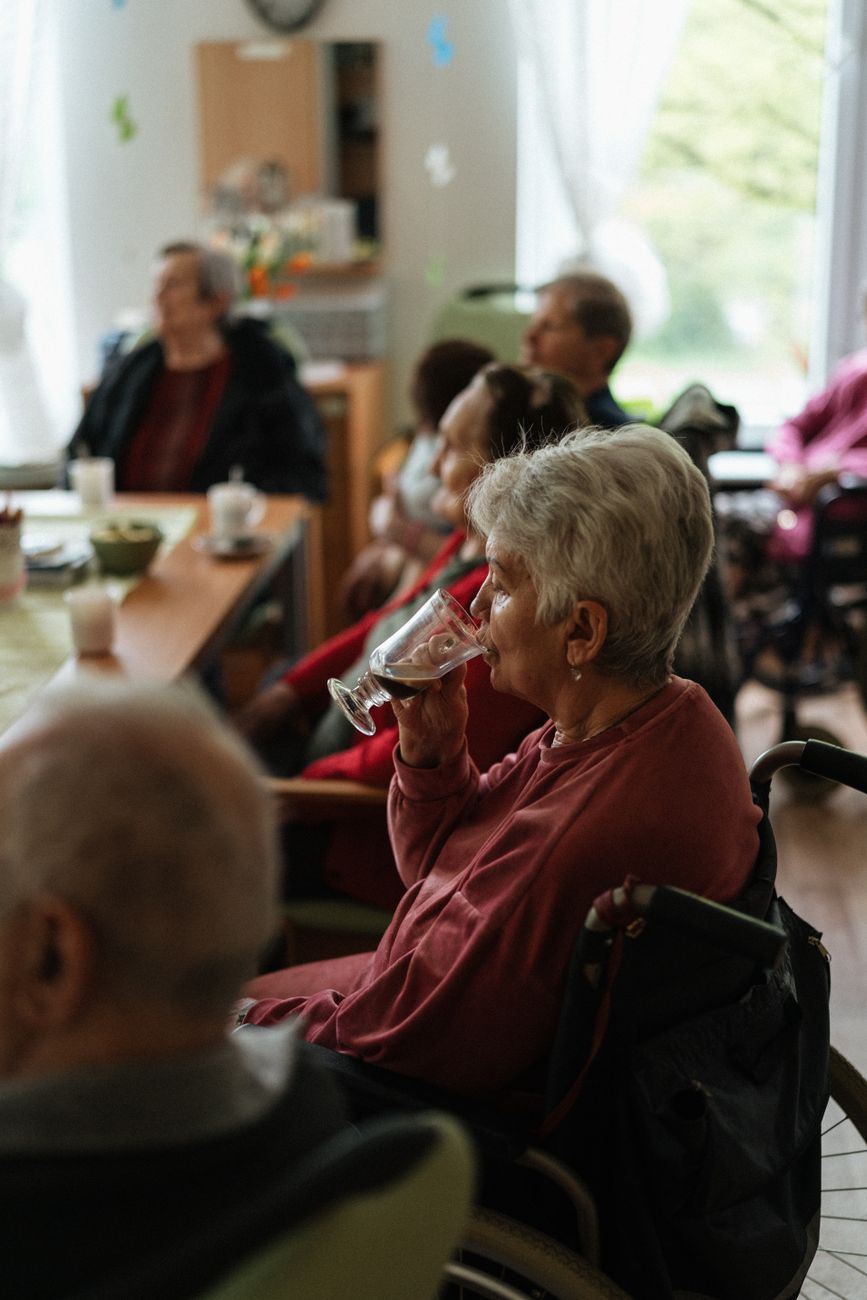 elderly woman drinking coffee at meeting