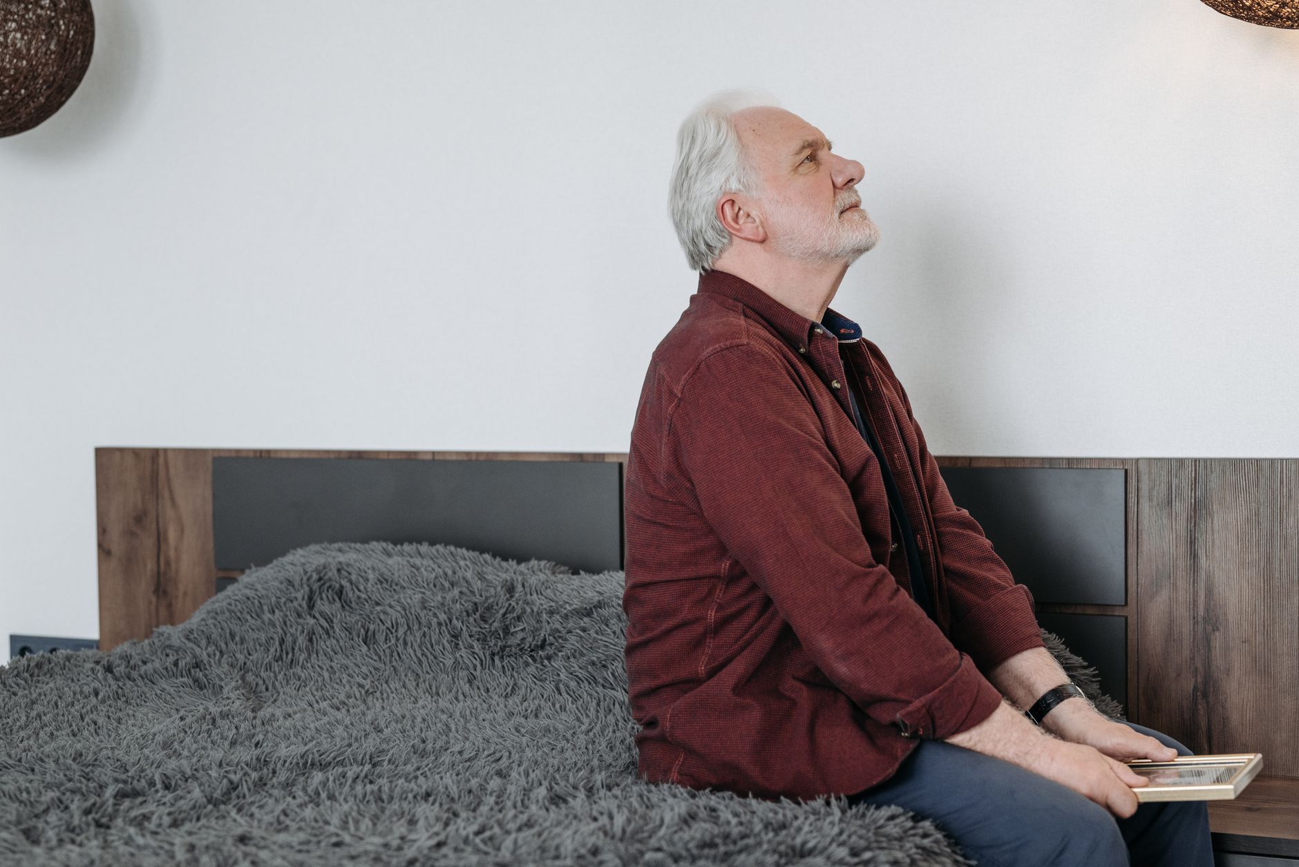 pexels-photo-8057101 elderly man sitting on the bed holding a picture frame