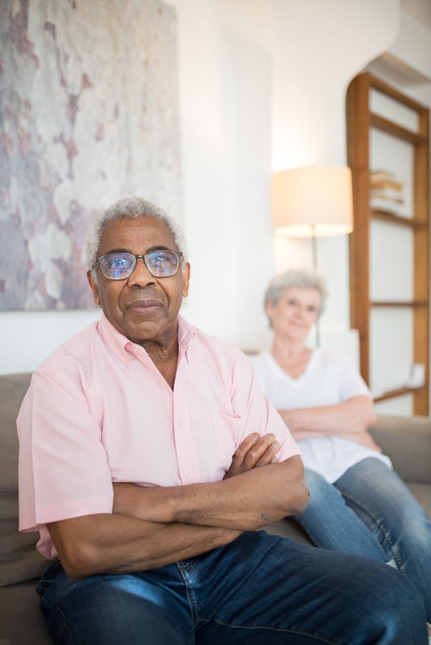 pexels-photo-8871552 an elderly man sitting on the couch with his arms crossed